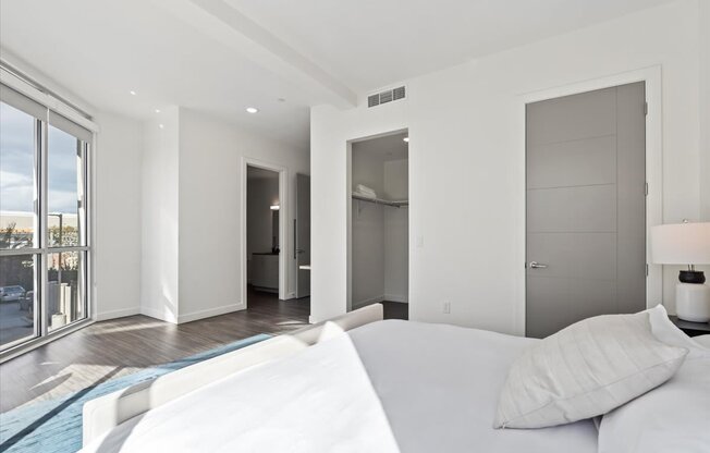 A white couch sits in a bright room with a blue rug.