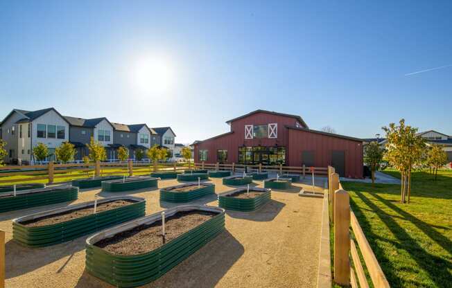 a park with benches and a barn with houses in the background