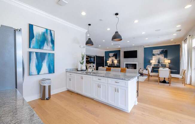 A kitchen with white cabinets and a marble countertop.