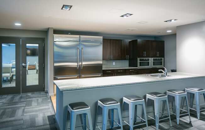 a large kitchen with a bar with blue stools