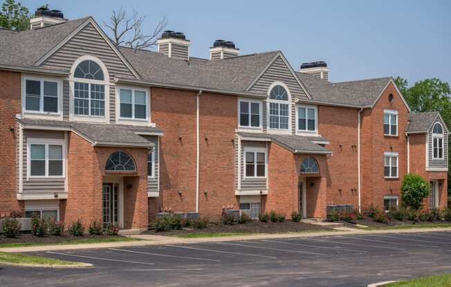 a large brick apartment building with a parking lot in front of it