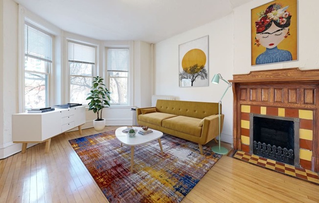 a living room with a yellow couch and a fireplace