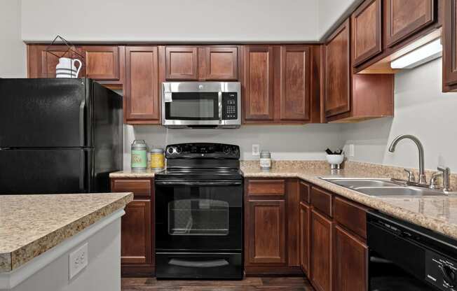 a kitchen with black appliances and granite counter tops