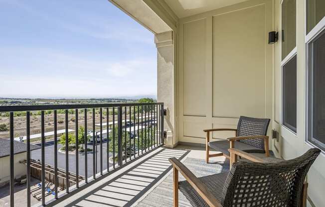 Private patio and balconies available a balcony with two chairs and a table and a view of the ocean