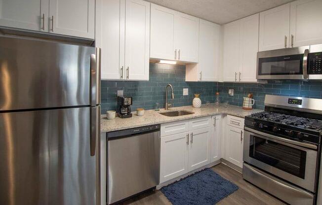 A modern kitchen with a stainless steel refrigerator, microwave, oven, and sink. at Paces Ridge at Vinings, Atlanta