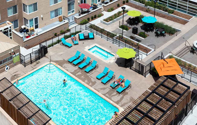 an overhead view of a swimming pool with chairs and umbrellas