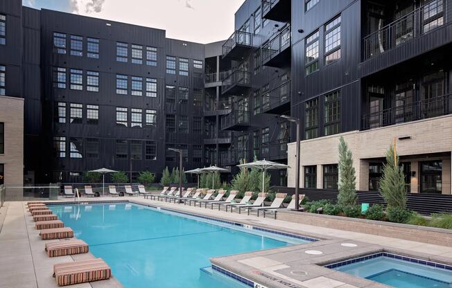 Pool and spa deck designed for relaxation, featuring a bar area and fire pit seating