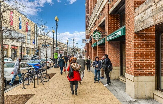 people walking down a city street in front of a brick building