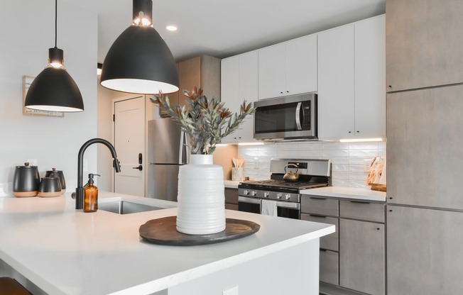 a kitchen with white cabinets and a white counter top at The Bohen Apartments, Minnesota, 55408