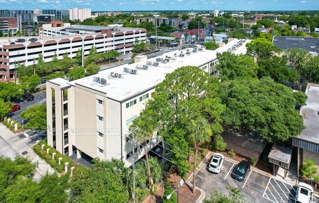 an aerial view of a building with cars parked in a parking lot