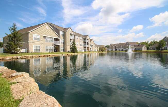 This is a picture of a pond with a fountain and  building exteriors at Nantucket Apartments, in Loveland, OH.