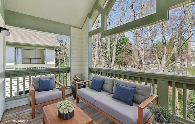 A wooden sofa with blue cushions is on a porch.
