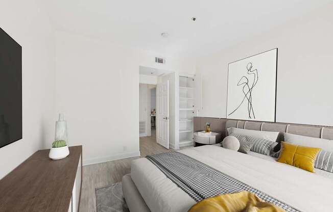 A bedroom with a bed, a couch, a coffee table, and a painting on the wall.