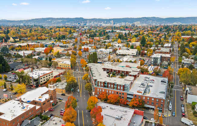 A cityscape with buildings and trees in autumn colors.