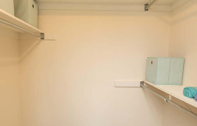 A small, empty room with a shelf and a mirror.