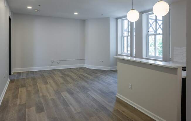 a kitchen and living room with white walls and wood floors