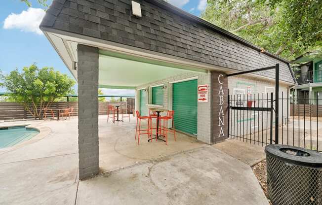 a patio with a table and chairs outside of a house with a pool