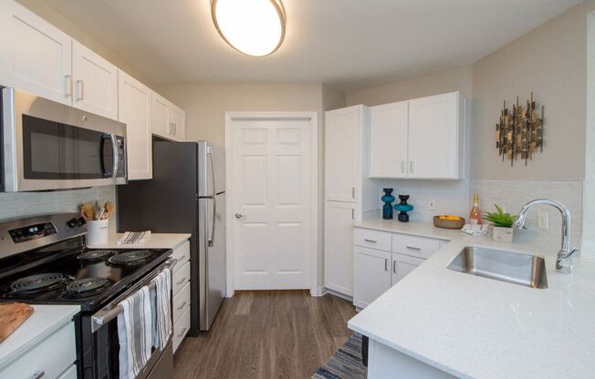 a kitchen with white cabinets and black appliances