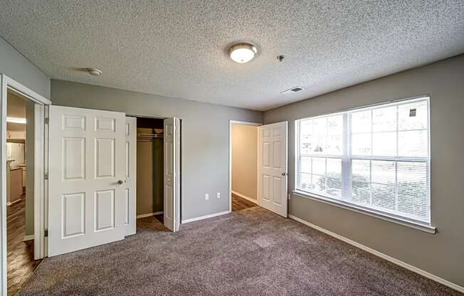 a living room with a large window and a door to a closet