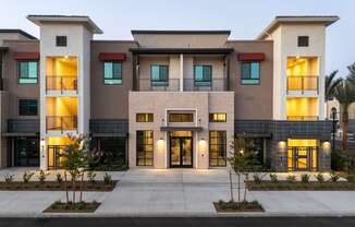 A modern building with a central entrance and multiple balconies.