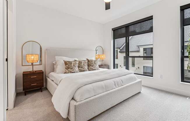 A bedroom with a large bed and two lamps on side tables.