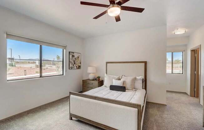 A bedroom with a large bed and a ceiling fan.