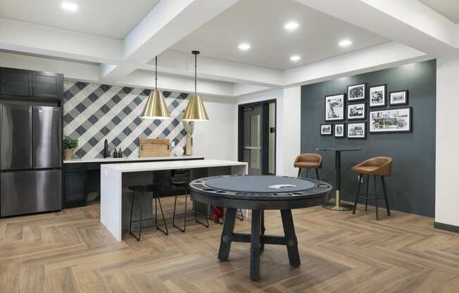 a living room with a round table and a kitchen with a refrigerator