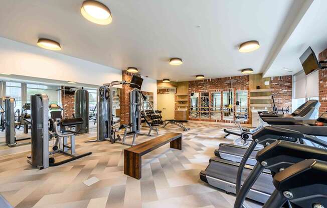A gym with treadmills, weights, and exercise equipment.