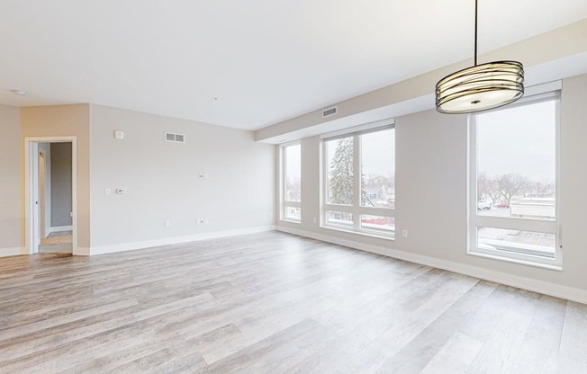 the living room with hardwood floors and large windows