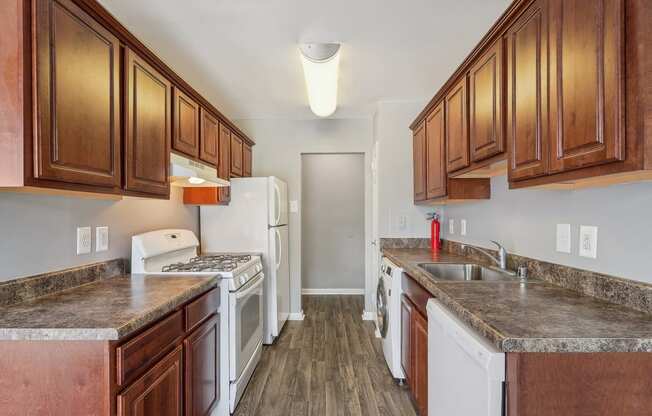 a kitchen with white appliances and wooden cabinets