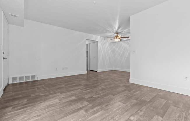 a bedroom with hardwood floors and white walls