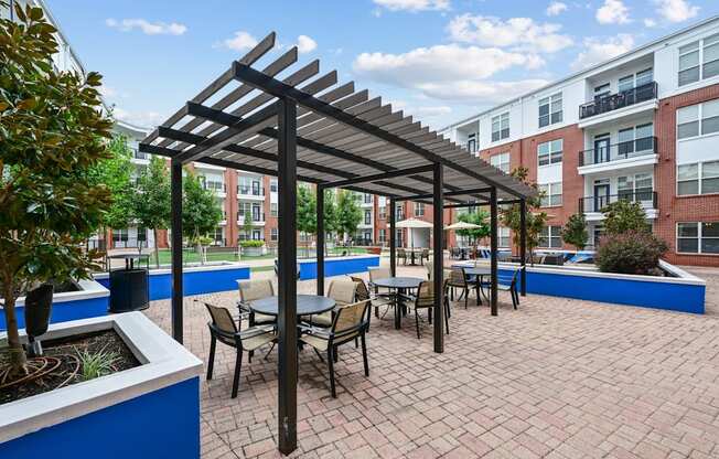 Pergola-covered outdoor dining area at The Grand at Upper Kirby apartments in Houston, TX