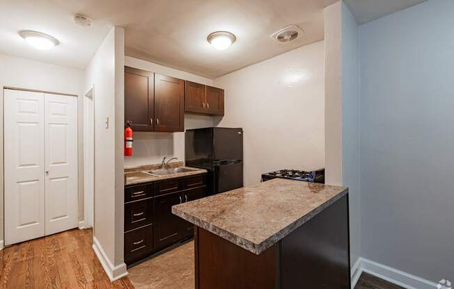 A kitchen with a granite countertop and wooden cabinets.