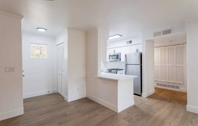 A kitchen with white cabinets and a refrigerator.