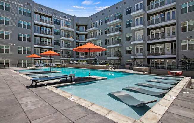 A large swimming pool surrounded by apartment buildings.