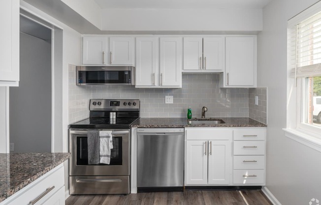 a kitchen with white cabinets and stainless steel appliances