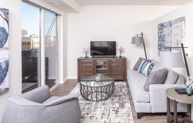a living room with a couch and a chair and a tv at Maven on Broadway, Rochester, MN