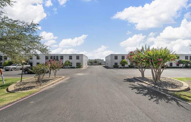 an empty parking lot with apartment buildings on both sides of it at Brookside Apartments, Texas, 76643