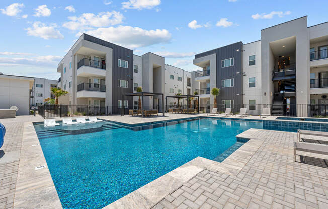a swimming pool with apartment buildings in the background