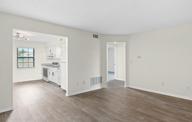 Gold living room interior with view of kitchen at The Arbor Apartments in Blue Springs, Missouri