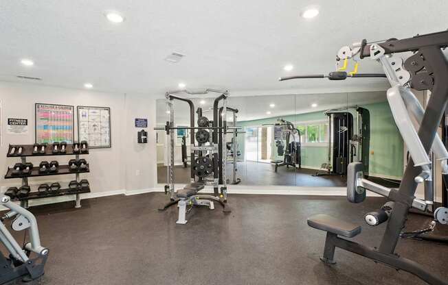 A gym with a variety of equipment including weights and machines.