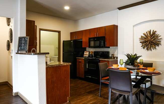 full kitchen with black appliances and a dining table with chairs