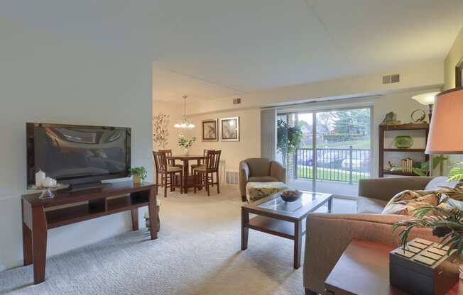 Apartments in Harrisburg | Twin Lakes Apartments | a living room with a television and a dining room in the background