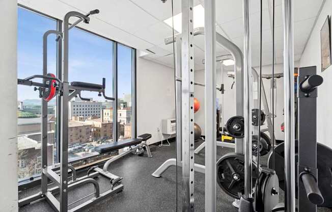 A gym with a view of the city outside the window.