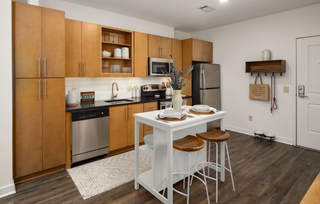 a kitchen with wooden cabinets and a white table with stools