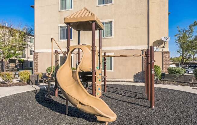 a playground with a slide in front of a building