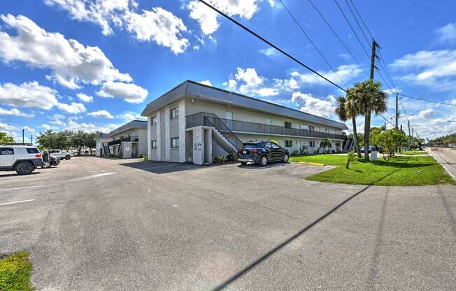 A sunny day at a parking lot with a white building in the background.