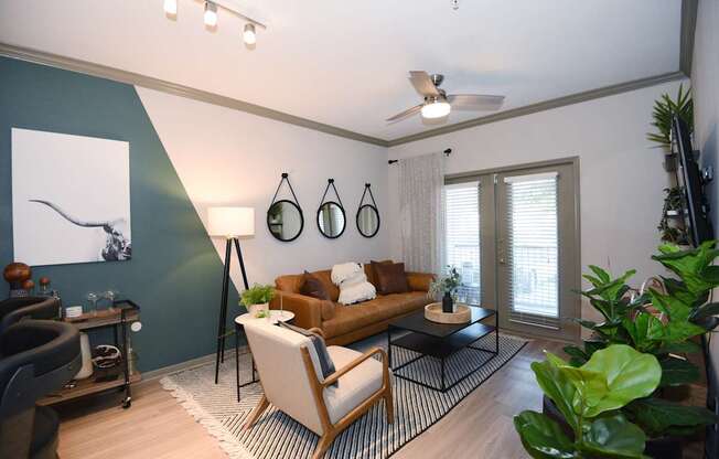 A living room with a brown couch, a black floor lamp, and a painting on the wall.