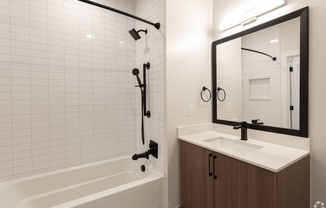 a bathroom with a white tub and a sink and a mirror