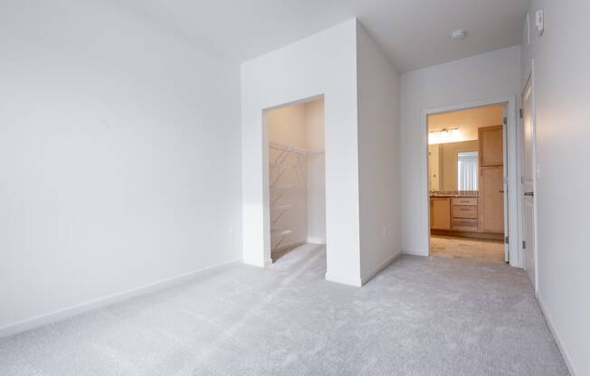 an empty bedroom with a closet and a bathroom